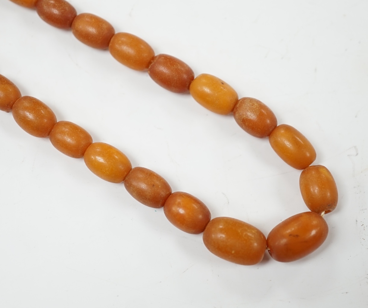 A single strand graduated amber bead necklace, 86cm, gross weight 30 grams. Condition - poor to fair